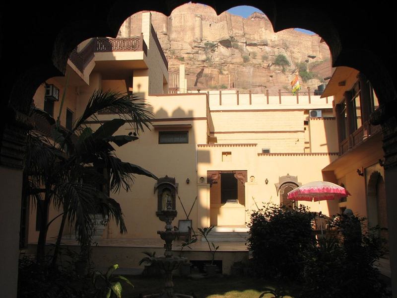 Guesthouse courtyard in Jodhpur with Mehrangarh Fort behind an arch