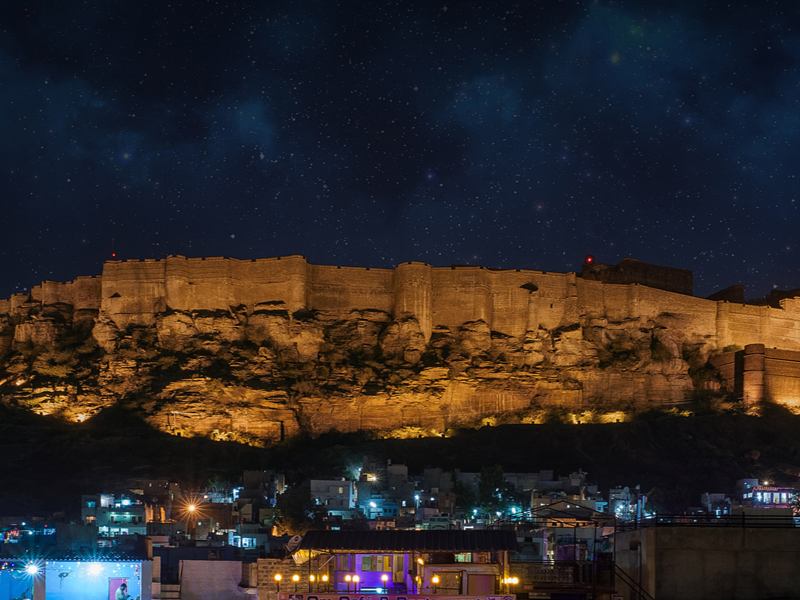 Mehrangarh Fort lit up at night above Jodhpur’s rooftops