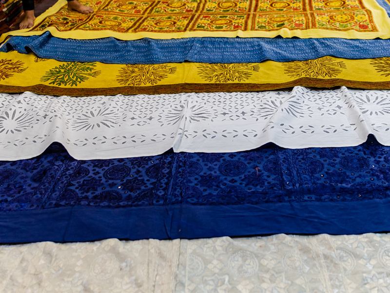 Embroidered and cut-work bedspreads laid out at Sardar Market, Jodhpur