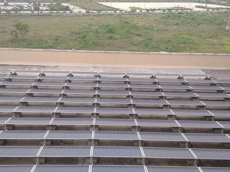 Rows of solar panels on the flat roof of a multi-storey building