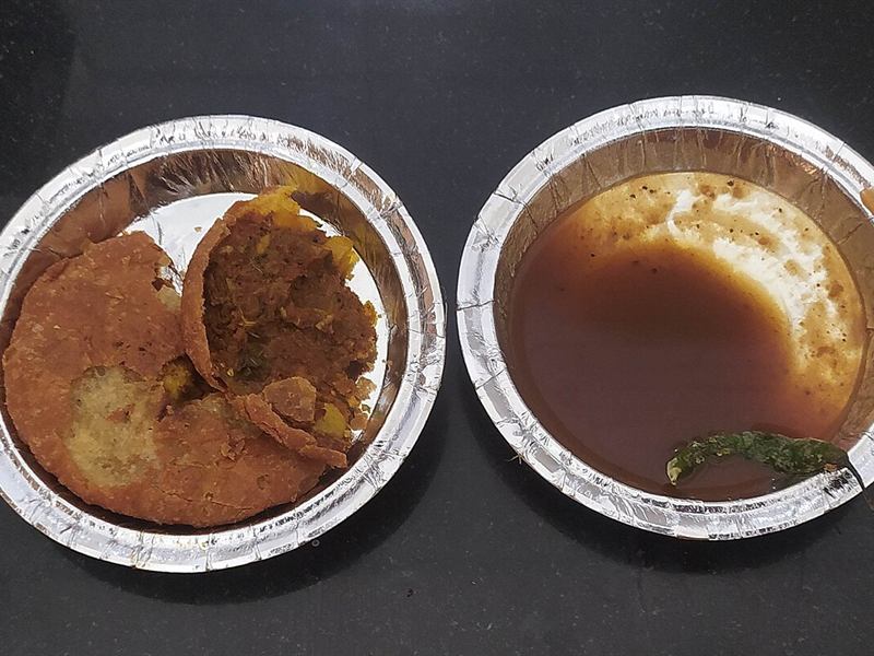 Jodhpuri pyaaz kachori with tamarind chutney in foil bowls