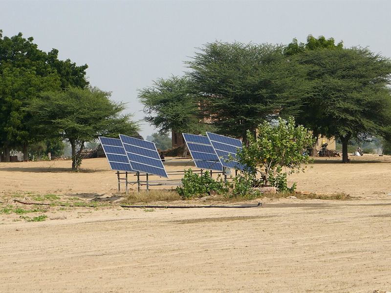 Two solar panel arrays standing on dry land in the Thar desert